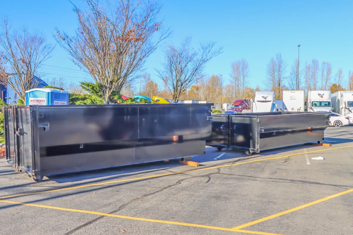 Professional dumpster rental service with roll-off container on residential driveway in Riverdale